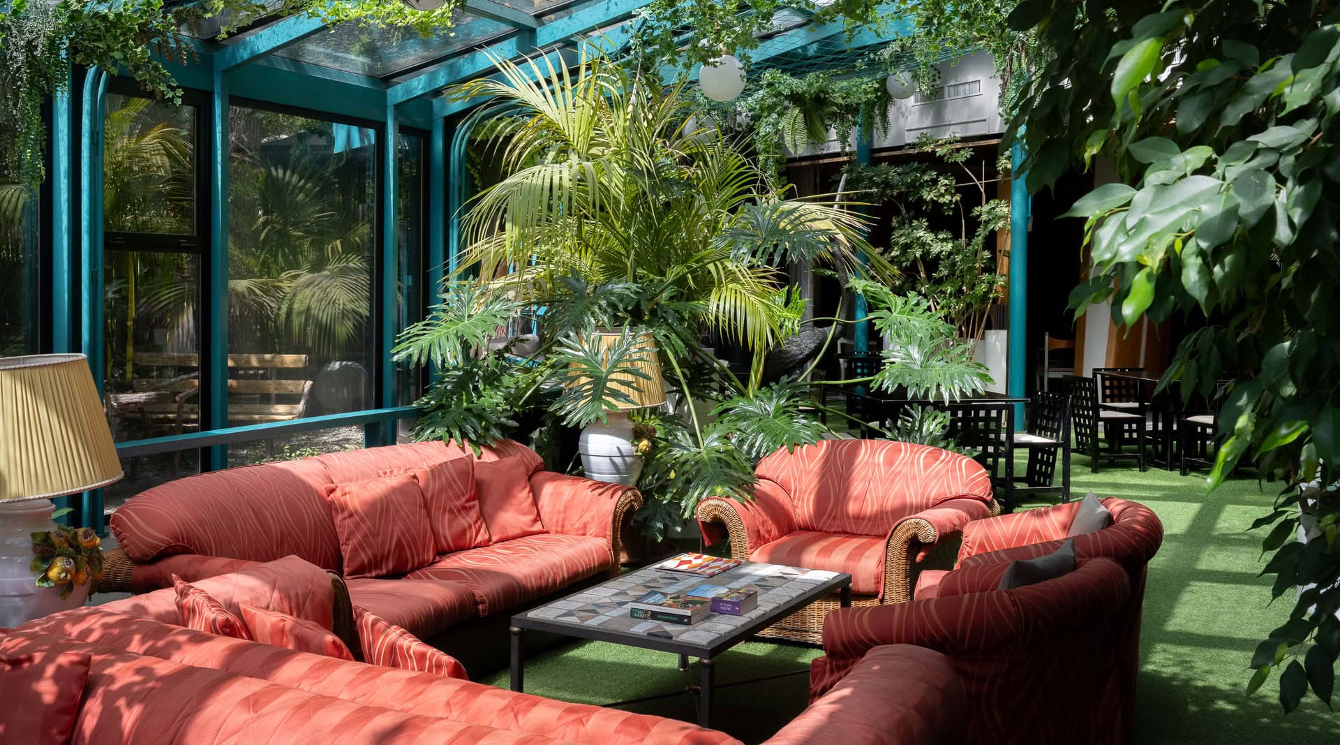 Salottino interno del Grand Hotel Panoramic con grandi vetrate e piante verdi